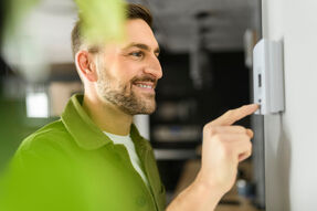 Ein Mann stell ein Thermostat ein