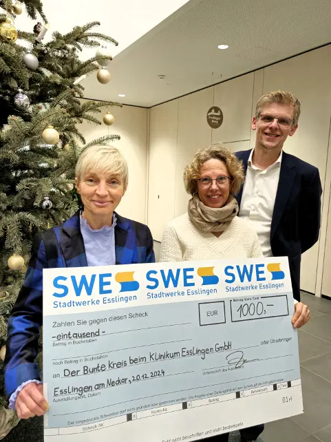 Das Bild zeigt 3 Personen bei einer Scheckübergabe der SWE-Weihnachtsspende am 20. Dezember 2024