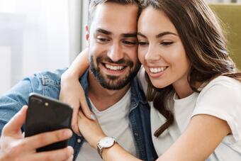 Mann und Frau schauen gemeinsam auf ein Handy Mann und Frau schauen gemeinsam auf ein Handy