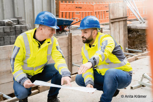 Zwei Fachleute der Stadtwerke Esslingen bei einer Besprechung auf einer Fernwärme-Baustelle in Esslingen.