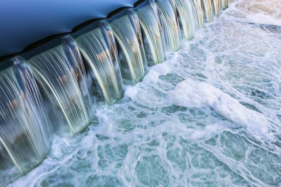 Wasser fließt über eine Stufe.